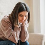 sad woman sitting on couch